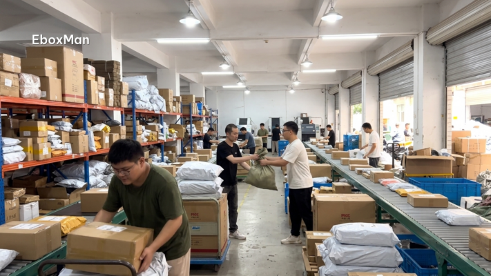 Warehouse staff moving parcels between sorting zones during a sourcing agent transition
