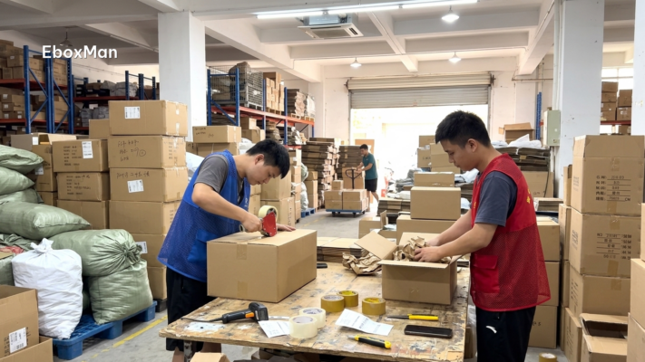 Warehouse staff sealing double-wall cartons for peak-season orders