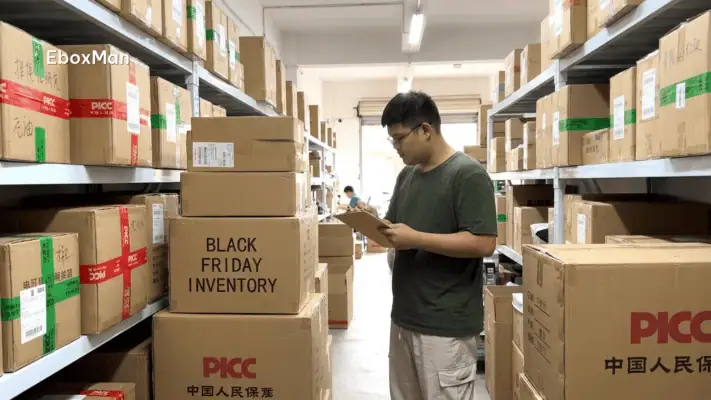 Warehouse staff reviewing stacked inventory boxes ahead of Black Friday